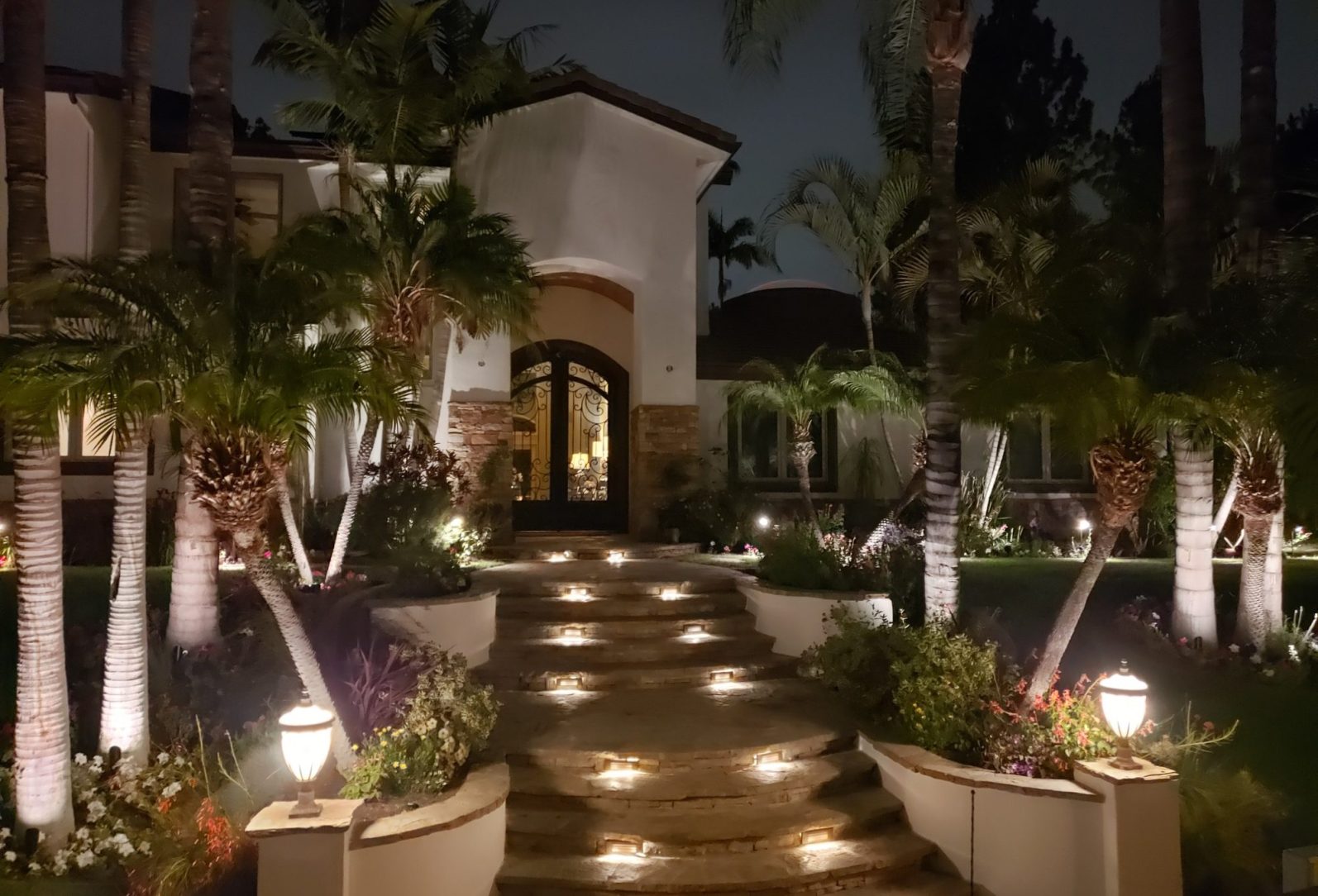 A home entry rebuilt by SierraVistaLandscape, lit by landscape lights at night
